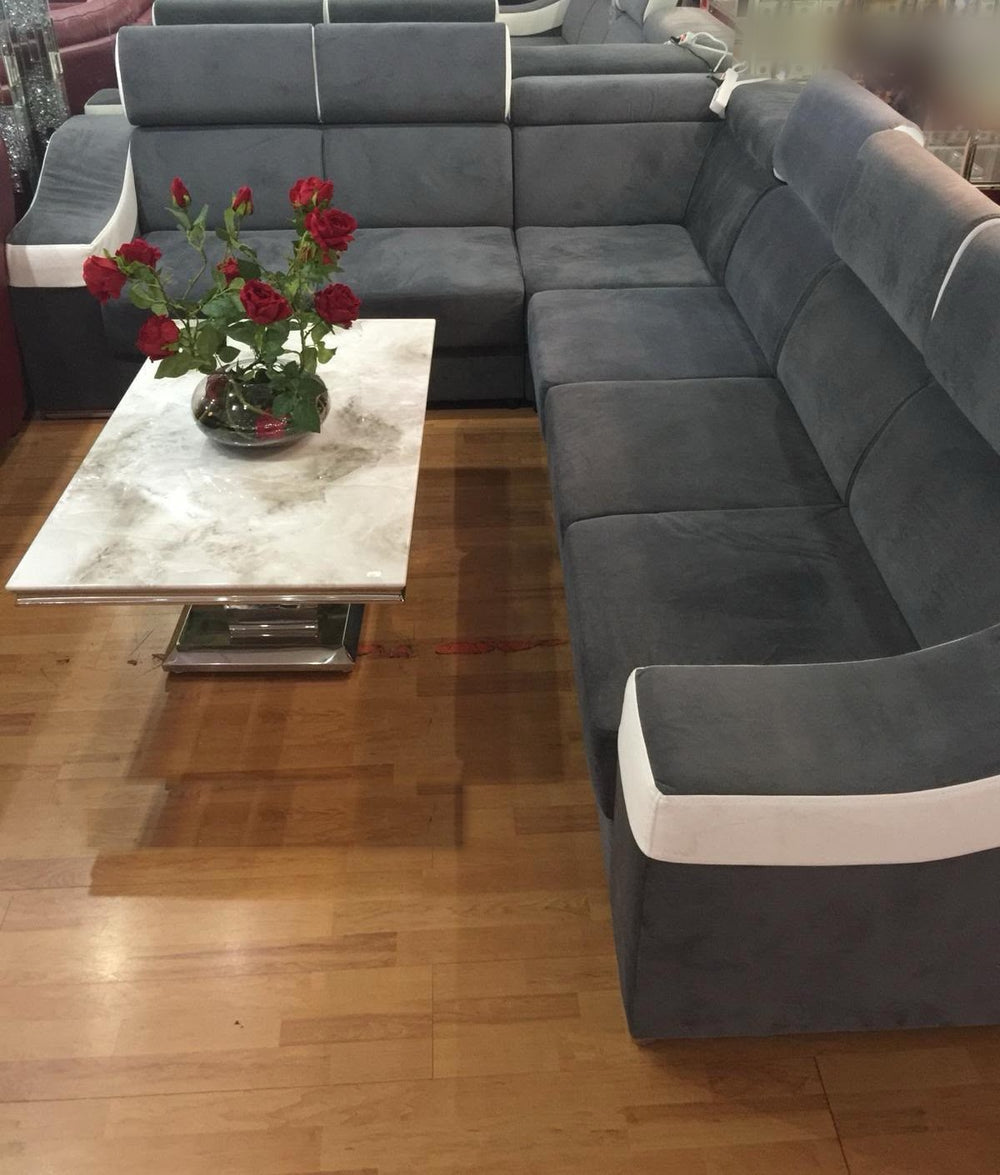 Canapé d'angle KLÉBER gris anthracite à bandes blanches et têtières réglables, photographié dans notre showroom