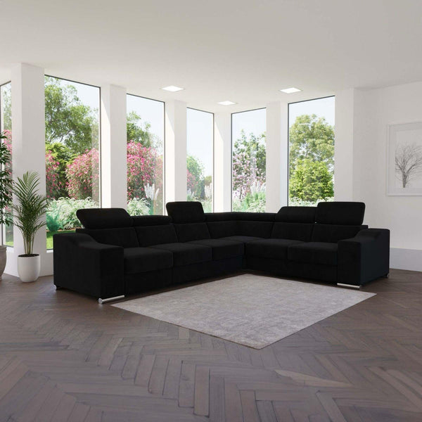 Canapé d'angle DAUPHINE en velours noir à têtières réglables, dans un séjour lumineux ouvert sur le jardin