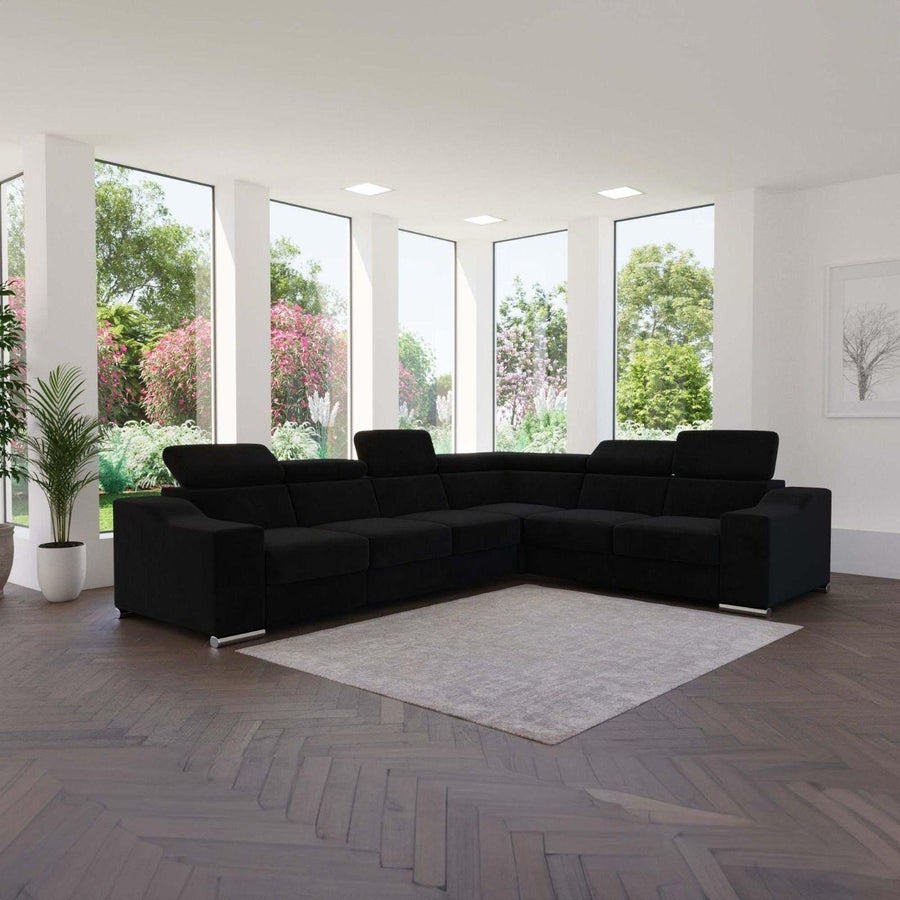 Canapé d'angle DAUPHINE en velours noir à têtières réglables, dans un séjour lumineux ouvert sur le jardin